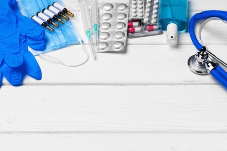 Medical equipment. Stethoscope, mask and pills on wooden desk close upの写真素材