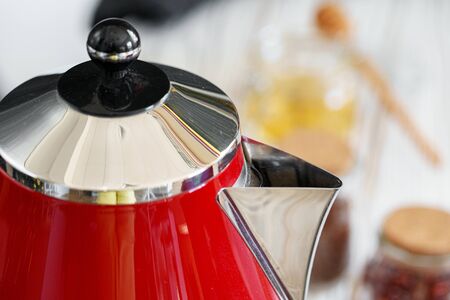 Red kettle on kitchen counter close up