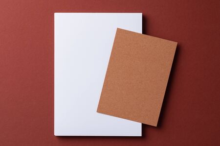 Blank white business cards on burgundy paper background, top viewの写真素材