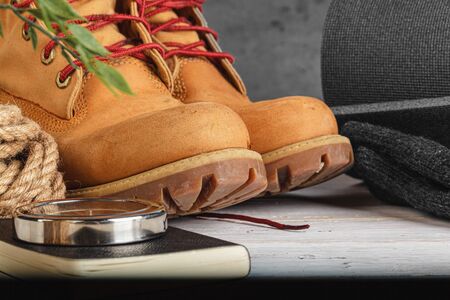 Hiking boots and rope hank on wooden boardの写真素材