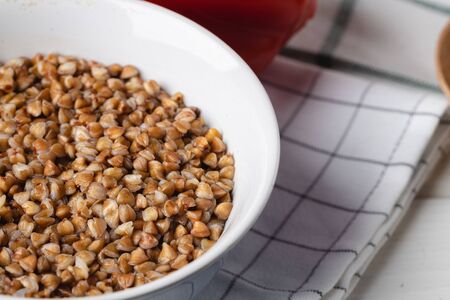 Cooked buckwheat in white bowl on napkin close upの写真素材