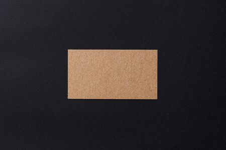 Business card of a craft paper on black background, top viewの写真素材