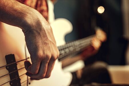 Close up of male hand playing electric guitar in the darkの写真素材