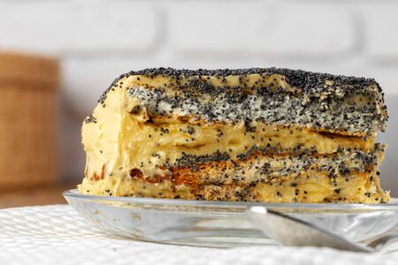 Piece of cake with poppy seeds on glass plate close upの写真素材