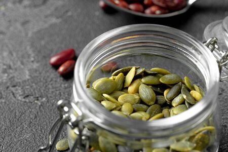 Red beans and pumpkin seeds on dark surface close upの写真素材