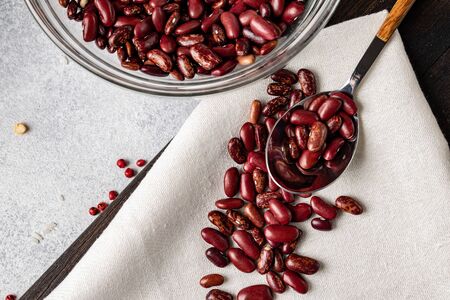 Heap of uncooked beans in a spoon on kitchen table