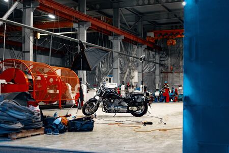 Motorcycle standing in a dark hangar buildingの写真素材