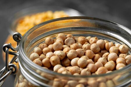 Uncooked dried chickpeas in glass jar close upの写真素材