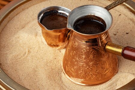 Process of preparation of coffee in turk in cezve on sandの写真素材