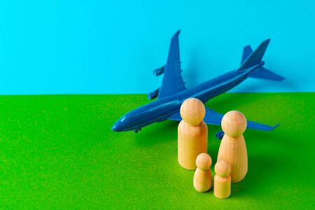 Family travel and vacation concept. Wooden figures of family and toy planeの写真素材