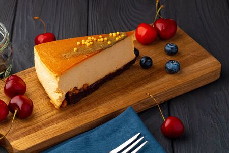 Piece of souffle cake with caramel top served with berriesの写真素材