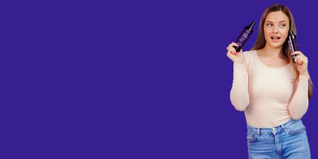 Attractive young caucasian woman presenting cosmetic products bottlesの写真素材