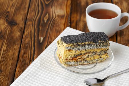 Piece of cake with poppy seeds on glass plate close upの写真素材