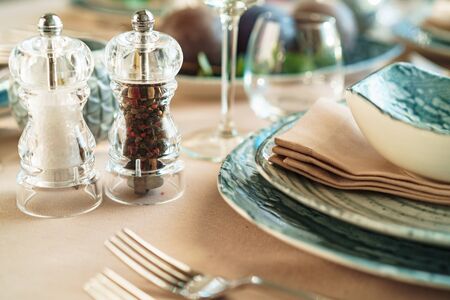 Beautiful elegant table setting with green stylish dishware and silver cutleryの写真素材
