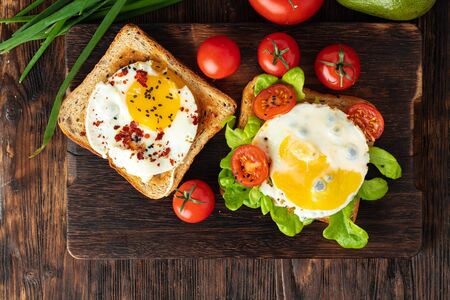 French toast with fried egg close up on wooden boardの写真素材