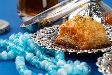 Turkish dessert in metal traditional plate on blue background close upの写真素材