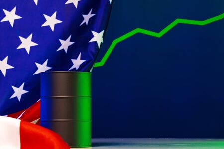 Price of american oil is changing concept. Black barrel with oil and graphの写真素材