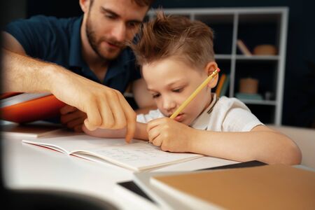 Father helping his little son with school homeworkの写真素材