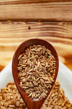 Wooden spoon with raw uncooked oats grain close upの写真素材