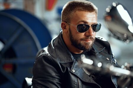 Portrait of motorbike rider in black leather outfit