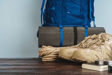 Hiking boots and rope hank on wooden board close up