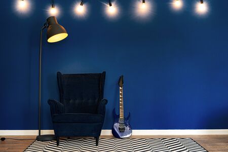 Guitar setup against classic blue wall in apartment