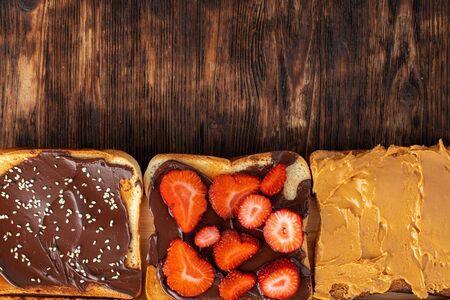 Assortment of sweet sandwiches with chocolate paste, peanut paste and fruit slicesの写真素材