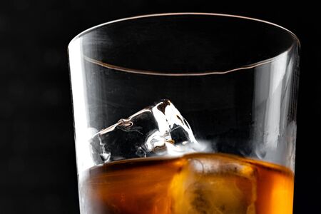 Whisky glass silhouette against dark black grunge wall