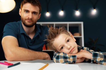 Dad and son doing school homework togetherの写真素材