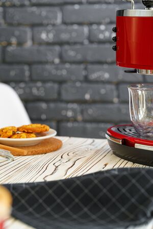 Red coffee machine with a glass on kitchen counter, close upの写真素材