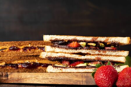 Sandwich toast with chocolate paste and cut strawberry on kitchen table