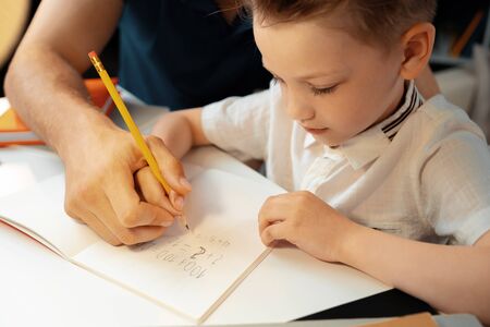 Little boy writing something in his notebook
