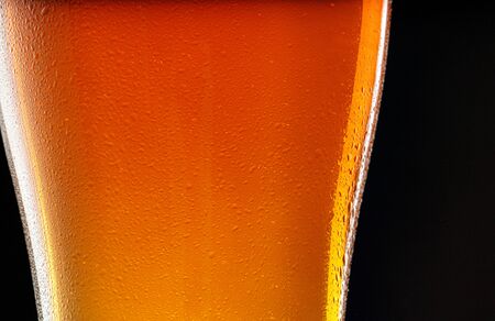 Glass of beer on black background, copy space. close up.
