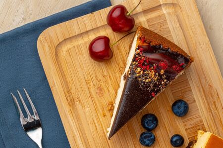 Vanilla cheesecake with chocolate top and berriesの写真素材