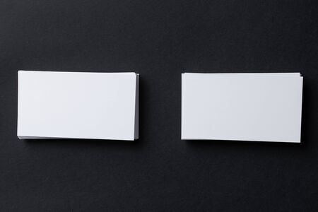 White blank business cards on dark black background, copy space