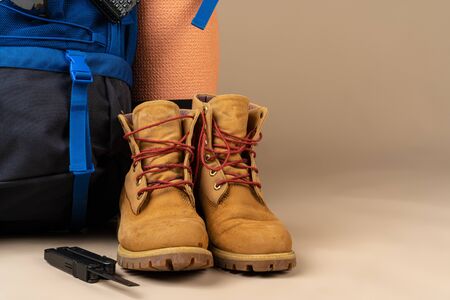 Blue backpack and hiking boots. Mountain gear close upの写真素材