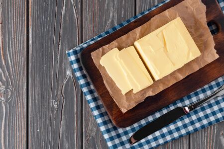 Wooden board with butter on blue checkered napkin. close up.の写真素材