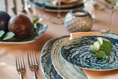 Beautiful elegant table setting with green stylish dishware and silver cutleryの写真素材