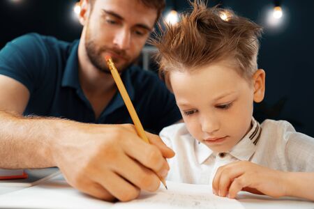 Father helping his little son with school homework