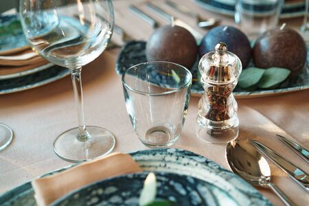 Beautiful elegant table setting with green stylish dishware and silver cutlery close upの写真素材