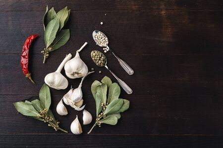 Top view of chili pepper, garlic and herbs on dark wooden surface, copy spaceの写真素材