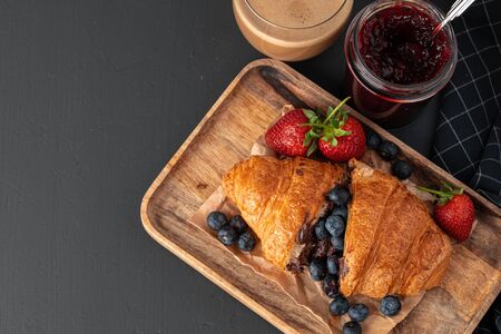 Tasty croissant with cup of coffee with milk on kitchen tableの写真素材