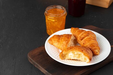 Fresh croissants on wooden board close up, copy spaceの写真素材