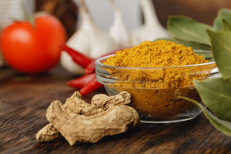 Turmeric powder in glass bowl on wooden table close upの写真素材