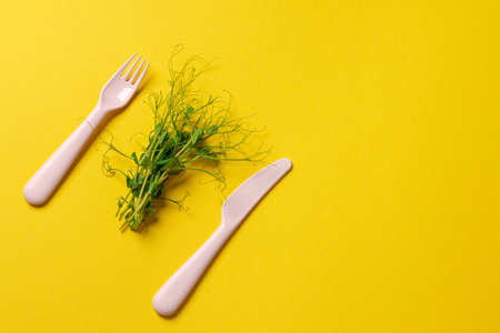 Healthy eating concept. Bunch of micro green with fork and knifeの写真素材