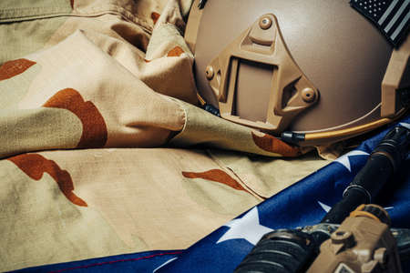 U.S. battle flag and assault rifle on the wooden table.