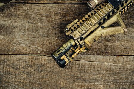 Close up photo of M16 rifle on wooden board close up