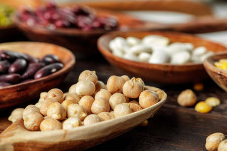 Wooden spoons with grains and beans on wooden table close upの写真素材