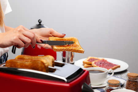Female hands preparing toasts with fruit jam close upの写真素材