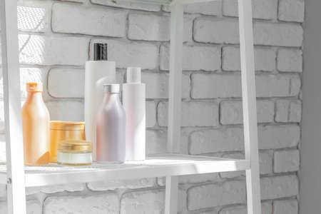 Cosmetic bottles against white bathroom wall background front viewの写真素材